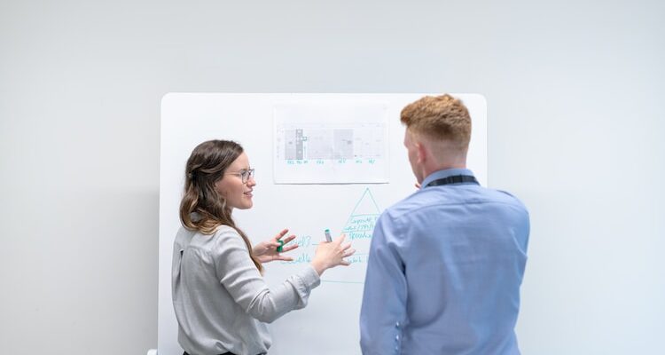 man in blue long sleeve shirt holding woman in gray sweater