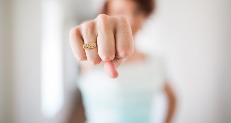 woman showing gold-colored ring